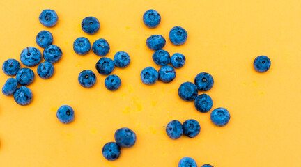 Tasty ripe blueberries on yellow background, flat lay