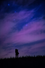 Lovely couple silouette with expectant mother gazing the night sky under de Ursa Major