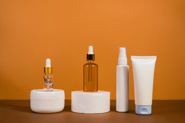 Copy space geometric shapes with night, day cream cosmetic oil, eye cream on yellow background. Unbranded bottles in mockup style. Beauty background with facial cosmetic products. Spa, beauty concept.