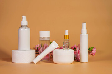 Copy space geometric shapes with night, day cream cosmetic oil, eye cream on yellow background. Unbranded bottles in mockup style. Beauty background with facial cosmetic products. Spa, beauty concept.