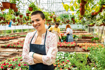 Portrait of female florists working with flowers in a greenhouse.