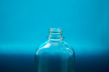 Small glass bottle neck on blue baclground