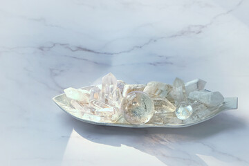 Set of clear quartz minerals on marble background. gemstones crystals for healing esoteric spiritual practice, relaxation, meditation. Reiki life balance concept