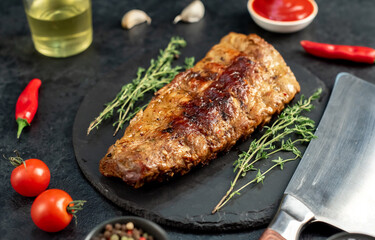 grilled pork ribs with spices on a stone background
