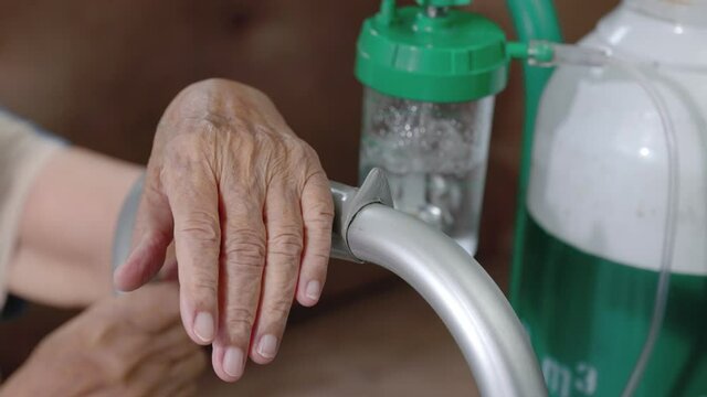 Elderly woman wearing oxygen nasal canula at home.