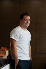 Young man with Down Syndrome smiling in the kitchen
