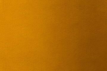 Gold or yellow paint on cement wall texture as background