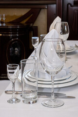 Serving table, wine glasses, plates, napkins and cutlery, festive dinner table design, service in restaurant or cafe, selective focus