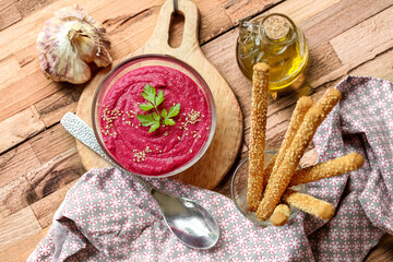 Houmous de betterave avec gressins sur table en bois