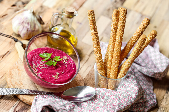 Houmous de betterave avec gressins sur table en bois