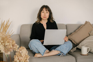 Busy focused asian woman freelancer working remotely on laptop from home, remotely working concept