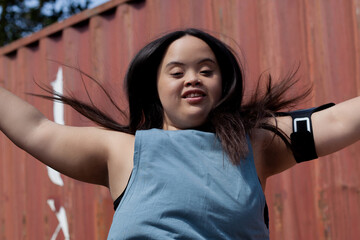 Young biracial woman with Down Syndrome in active wear and wearable tech working out