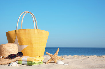 Bag and beach accessories on seaside. Space for text