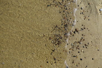 Soft sea wave on clean sandy beach. Abstract sand of beach and soft wave background. Top view