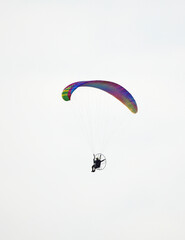 Paragliding with a motorized paraglider. Colorful paraglider in flight.