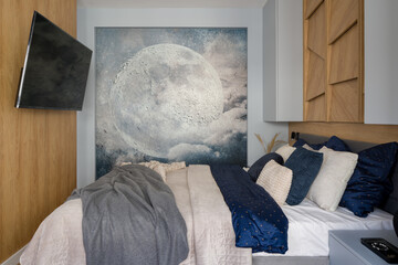Small bedroom with tv and poster with moon