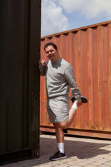 Young man with Down Syndrome stretching his legs and smiling