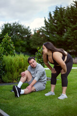 Young biracial couple with Down Syndrome in active wear stretching and smiling