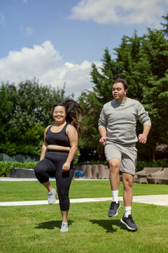 Young biracial couple with Down Syndrome working out together and having fun