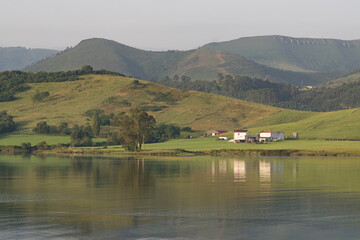 Reflection landscape of San Vicente de la Barquera marsh and ships and boats in a calm day, Cantabria, Spain
