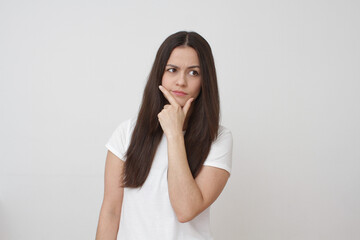 Pensive girl on grey background. 