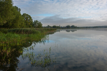 Morning on the lake with the reflection of the sky and clouds