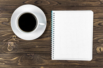 Obraz na płótnie Canvas Notebook and cup of coffee on a wooden table. Background. Design. Business
