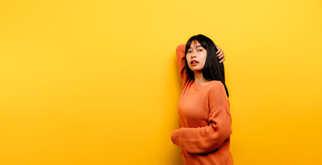 Obraz premium Cute Asian girl smiling on yellow background. Empty, young woman. Place for advertisement. copy space