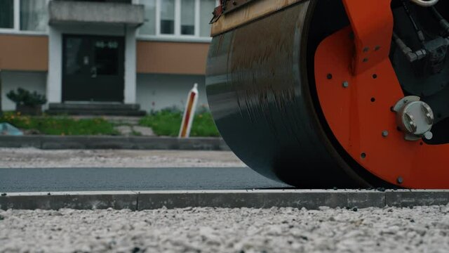 Road reconstruction. Heavy vibration road roller stacking hot asphalt.