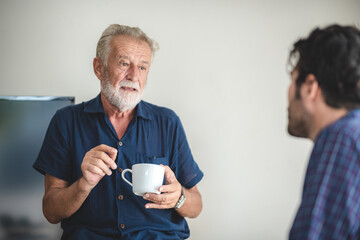 Adult hipster son and old senior father stay for work at home, two generations have a beard talking together and relaxing with smile, happy enjoy living to isolation quarantine at home, father's day