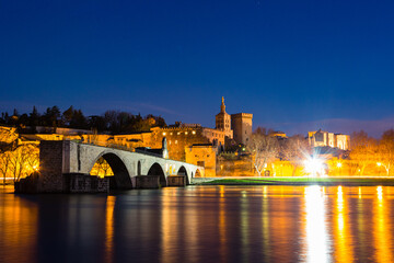 Fototapeta na wymiar フランス　ライトアップされた夜のアヴィニョンのサン・ベネゼ橋と後ろに見える旧市街の城壁とノートルダム・デ・ドン大聖堂