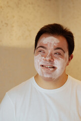 Young man with Down Syndrome with face mask having fun in the bathroom