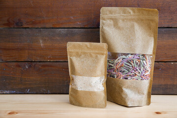 A pack of veggie noodles and instant soup (tarhana), in front of a wooden backdrop