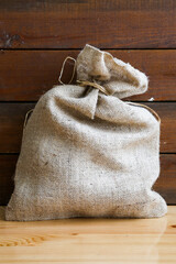 a tied linen sack in front of a wooden backdrop