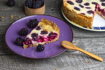 Slice of blackberry pie on wooden background
