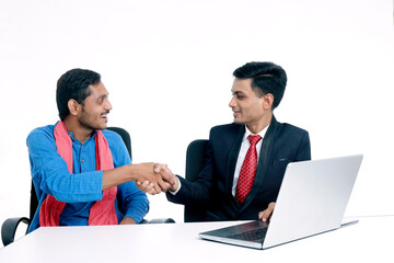 Financial adviser shaking hands with a farmer at office