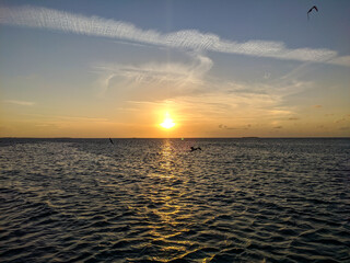Sunset over the ocean with seagulls flying over the water. Cayo Guillermo, Cuba.