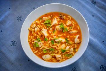 Fish soup with pasta in the hands of the cook.