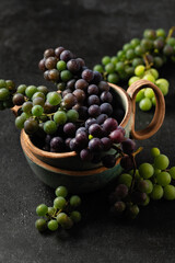 grape bunches in ceramic cups on gray background