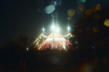 Glowing lights of a big top circus. With a bokeh blurred out of focus edit