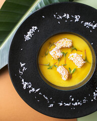 Mango soup. Tropical cuisine on brown backgrounds. Exotic food. Fruit orange soup.