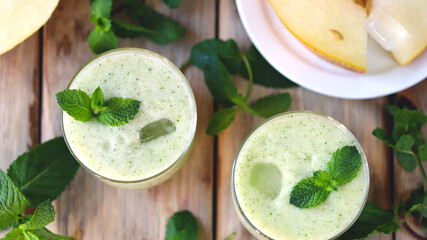 Smoothie melon mint in glasses on a wooden surface. Refreshing detox summer drink.