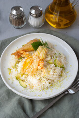 Zucchini risotto with olive oil and sauteed flowers zucchini.