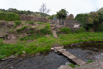 A wooden plank bridge to cross the Arrago river and access the organic garden and chicken coop