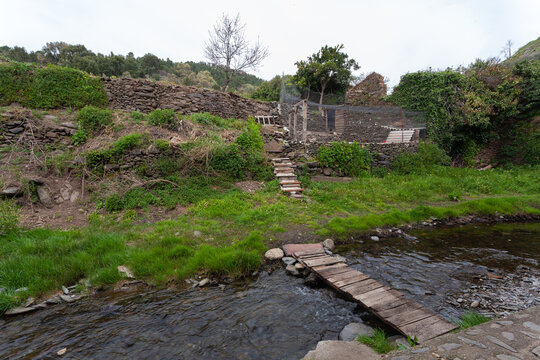 A wooden plank bridge to cross the Arrago river and access the organic garden and chicken coop