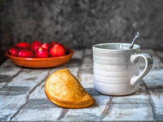Breakfast with a pie and tea in a gray large mug, ripe plums