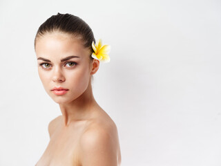 Fototapeta premium pretty woman with bare shoulders yellow flower in hair charm isolated background