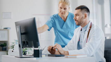 Hospital Medical Doctor Office: Head Nurse Consults Physician with Working on Computer. Professionals Discuss Patient Online Treatment, Video Call Consultations, Writing Digital Prescriptions