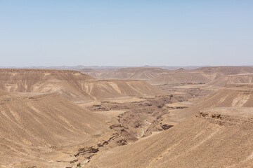 blue sky and vast dirt valley landscape like mars of hadramaut, yemen