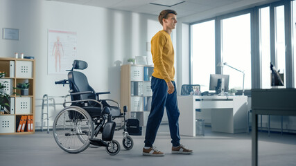 Hospital Physical Therapy: Determined Young Man with Injury Successfully Stands up from Wheelchair...